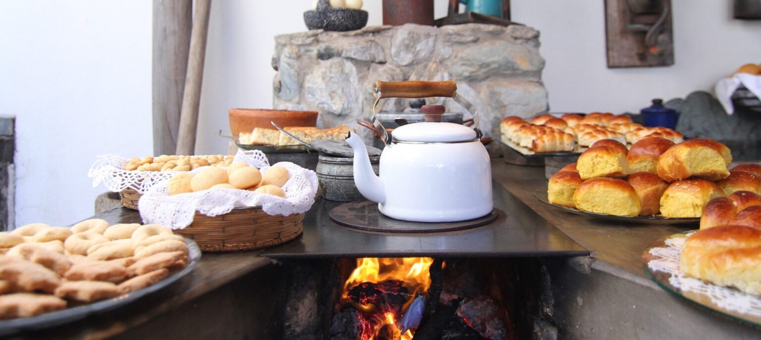 Homemade breakfast spread with a kettle over a wood fire at Teu Living