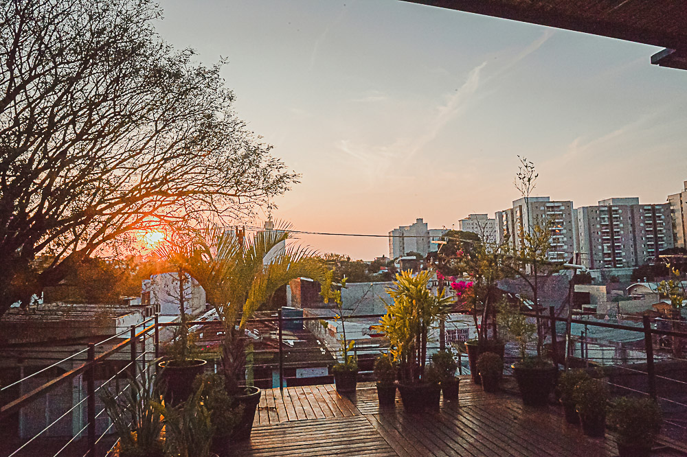 Teu Living rooftop garden at sunset overlooking São Paulo